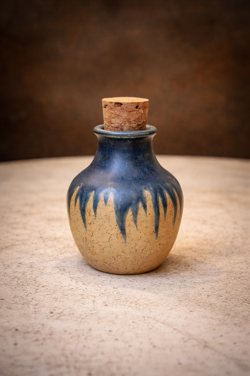Hand-thrown ceramic jar with a natural cork stopper and blue dripping glaze over speckled clay by Corax Ceramics.