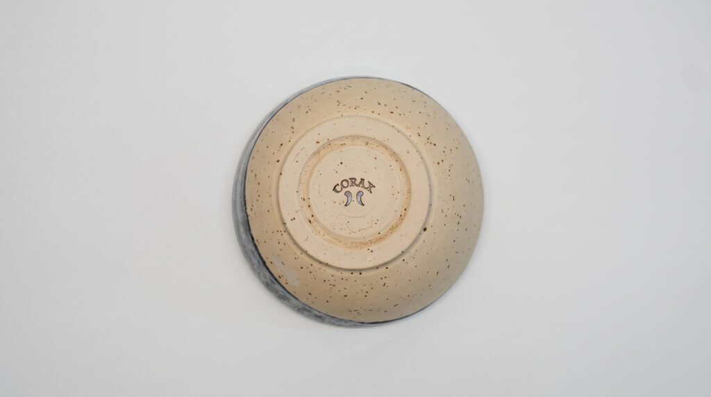 a ceramic stoneware hand thrown bowl with a custom made logo on the bottom